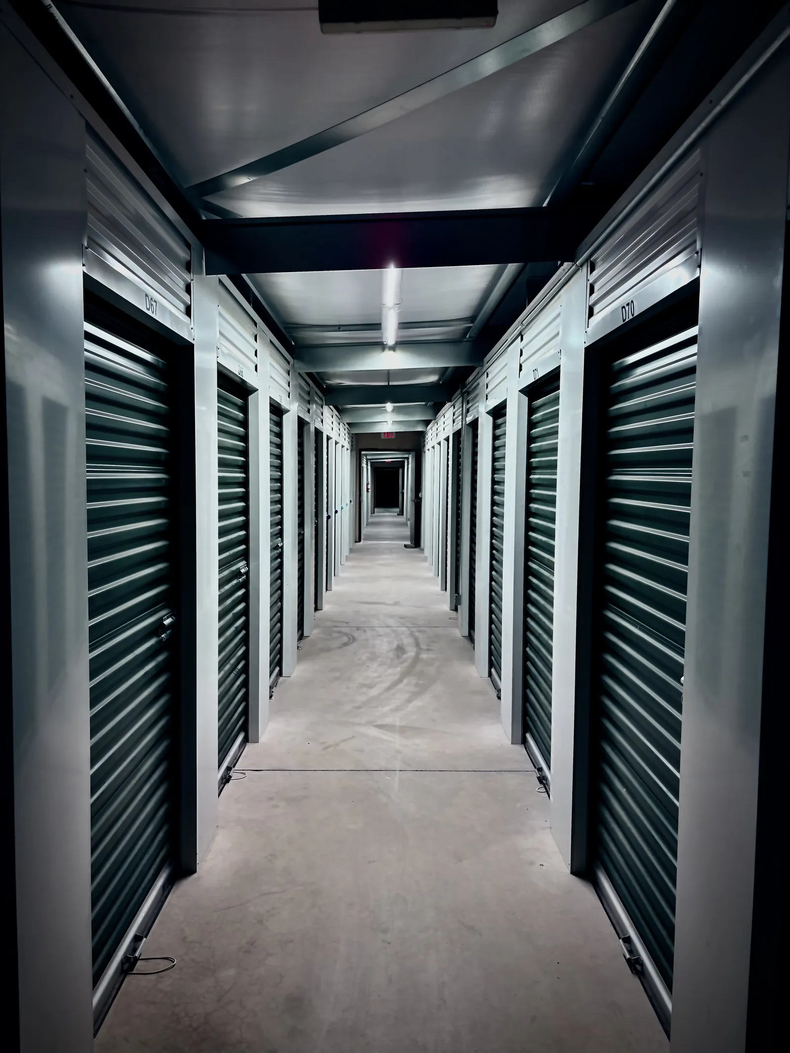 An indoor self-storage hallway lined with roll-up unit doors